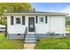 Charming home with crisp white siding, black shutters, and security system sign in the front yard at 1301 Jackson St, Kannapolis, NC 28083