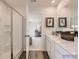 Bright bathroom with dual vanity, walk-in shower, and wood-look flooring at 156 Mountain Bridge Way, Statesville, NC 28625