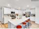 Bright kitchen boasts stainless steel appliances, a center island with seating, and white cabinetry at 160 Mountain Bridge Way, Statesville, NC 28625