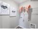 Modern laundry room boasting a shelf with towels, whimsical dog art, and vinyl plank flooring at 160 Mountain Bridge Way, Statesville, NC 28625