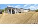 View of gray home exteriors with covered patios and expansive lawn at 1774 Slippery Rock Ln, Monroe, NC 28112