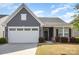 Charming one-story home with a gray exterior, brick accents, well-manicured lawn, and a two-car garage at 1774 Slippery Rock Ln, Monroe, NC 28112