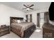 Comfortable main bedroom features a ceiling fan, large bed and two windows with curtains at 1774 Slippery Rock Ln, Monroe, NC 28112