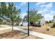 A street view of a well-maintained one-story home with lush trees and manicured landscaping at 1774 Slippery Rock Ln, Monroe, NC 28112