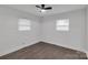 Bright bedroom featuring two windows for natural light, ceiling fan and hardwood floors at 1814 Eastway Dr, Charlotte, NC 28205