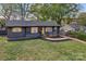 Charming, newly renovated home with black exterior, wood shutters, and a bright yellow door at 1814 Eastway Dr, Charlotte, NC 28205