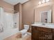 Standard bathroom with neutral brown walls, a single sink vanity, a mirror and shower-tub combo at 217 Blossom Hill Rd, Lincolnton, NC 28092