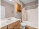 Well-lit bathroom with a single sink vanity, wall cabinet, and a tub-shower with floral shower curtain at 217 Blossom Hill Rd, Lincolnton, NC 28092