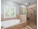 Bathroom showcasing a soaking tub and glass enclosed tile shower at 217 Blossom Hill Rd, Lincolnton, NC 28092