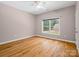 Bright, empty bedroom features hardwood floors, a ceiling fan, and a large window offering natural light at 217 Blossom Hill Rd, Lincolnton, NC 28092