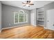 Comfortable bedroom featuring hardwood floors, a ceiling fan, large window, and built-in shelves at 217 Blossom Hill Rd, Lincolnton, NC 28092