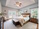 Comfortable main bedroom with tray ceiling, ceiling fan, bench, and french doors leading to an outside space at 217 Blossom Hill Rd, Lincolnton, NC 28092