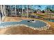 Inviting backyard features a cozy fire pit area, ideal for outdoor entertaining and relaxation by the water at 22970 Lake Tillery Rd, Albemarle, NC 28001