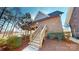 Brick home with staircase leading to wooden deck, surrounded by lush greenery and beautiful landscaping at 22970 Lake Tillery Rd, Albemarle, NC 28001