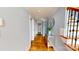 Hallway with hardwood floors, with mirror and plant, leading to rooms with ample natural light at 22970 Lake Tillery Rd, Albemarle, NC 28001