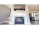Cozy living room with a fireplace, flat screen tv, stairway access to upper floors, and modern kitchen at 22970 Lake Tillery Rd, Albemarle, NC 28001