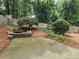 Peaceful backyard featuring a pond, tree, flowers and concrete patio space at 2620 Merion Hills Ct, Charlotte, NC 28269
