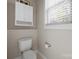 This bathroom includes a standard toilet, a window with blinds, and a cabinet at 2620 Merion Hills Ct, Charlotte, NC 28269