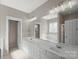 Bathroom features dual sinks, white cabinets, vanity and a large mirror at 2620 Merion Hills Ct, Charlotte, NC 28269