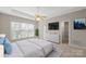 Comfortable bedroom with a ceiling fan, large window, and a walk-in closet at 2620 Merion Hills Ct, Charlotte, NC 28269