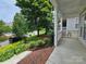 Inviting front porch with brick stairs and lush landscaping featuring yellow flowers at 2620 Merion Hills Ct, Charlotte, NC 28269