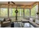 Relaxing screened porch with cozy seating, natural light, and serene views of the surrounding trees at 27 Heritage Ct, Lake Wylie, SC 29710