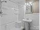 Bathroom features a white shower-tub combo, pedestal sink, and decorative lighting fixture at 28120 Ryan Rd, Richfield, NC 28137