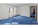 Bedroom features blue carpet, white walls, three windows with curtains, and a doorway to an adjoining room at 28120 Ryan Rd, Richfield, NC 28137