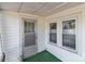 Close up of the white exterior front door with green carpeting on the porch, providing curb appeal at 28120 Ryan Rd, Richfield, NC 28137
