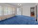 The living room is brightened by windows and features plush blue carpet at 28120 Ryan Rd, Richfield, NC 28137