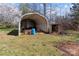 Exterior view of a metal storage shed surrounded by greenery on a sunny day at 28120 Ryan Rd, Richfield, NC 28137