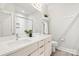 Bathroom with a double sink, sleek cabinetry, a decorative mirror, a separate toilet, and a glass-doored shower at 327 Uptown West Dr, Charlotte, NC 28208