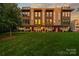 Beautiful townhome with well-manicured lawn and vibrant sunset reflecting in the windows at 327 Uptown West Dr, Charlotte, NC 28208