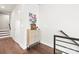 Hallway with art and shoe storage near a staircase. Hardwood floors throughout the space at 327 Uptown West Dr, Charlotte, NC 28208