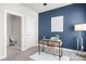 Stylish home office with a blue accent wall, modern desk, and convenient bathroom access at 327 Uptown West Dr, Charlotte, NC 28208