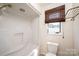 Bathroom featuring a tub/shower, toilet, window with blinds, and rack for storage at 343 River Haven Dr, Taylorsville, NC 28681