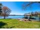 Picturesque waterfront view with a dock, boat shelter, and meticulously landscaped lawn at 343 River Haven Dr, Taylorsville, NC 28681