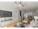 Bright open-concept living room with hardwood floors, modern decor, ceiling fans, and connecting dining area at 3939 Picasso Ct, Charlotte, NC 28205