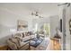 Bright living room with hardwood floors, modern ceiling fan, neutral decor, and balcony access at 3939 Picasso Ct, Charlotte, NC 28205