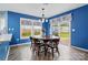 Bright dining room with blue walls, hardwood floors, wood table, and sliding glass doors to the backyard at 4919 Manchineel Ln, Monroe, NC 28110