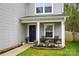 Inviting front porch with seating, featuring a well-manicured garden and stylish entryway at 4919 Manchineel Ln, Monroe, NC 28110