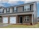 Two-story new construction townhome featuring an attached garage and brick accents and manicured lawn at 505 Mt. Mitchell Ave # 505, Gastonia, NC 28052