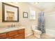 Well-lit bathroom featuring a wooden vanity, neutral walls, and a shower with a decorative blue patterned shower curtain at 5115 Sand Trap Ct, Monroe, NC 28112