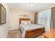 Comfortable bedroom features a wooden bed frame, neutral colors, and a window that lets in plenty of natural light at 5115 Sand Trap Ct, Monroe, NC 28112