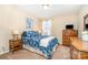 Cozy bedroom with bright blue floral bedding, complemented by wooden furniture and natural light from the window at 5115 Sand Trap Ct, Monroe, NC 28112