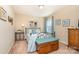 Bright bedroom with blue accents, featuring a metal bed frame, trunk at the end of the bed, and neutral walls at 5115 Sand Trap Ct, Monroe, NC 28112