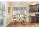 Cozy breakfast nook features a window, a small table and chairs next to the kitchen area with dark wood cabinets at 5115 Sand Trap Ct, Monroe, NC 28112