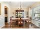 Formal dining room featuring a chandelier, large table, and a hutch with hardwood flooring and ample natural light at 5115 Sand Trap Ct, Monroe, NC 28112