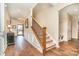 Elegant foyer featuring hardwood floors, staircase with iron spindles and an open entryway, creating a welcoming entrance at 5115 Sand Trap Ct, Monroe, NC 28112