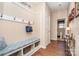 Hallway with hardwood floors, coat rack, bench with storage, and doorway leading to a bathroom at 5115 Sand Trap Ct, Monroe, NC 28112